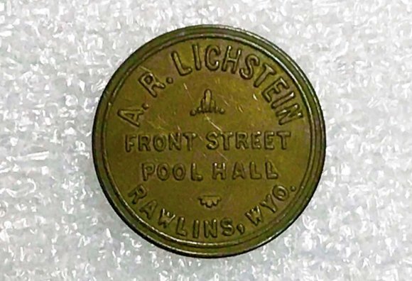 Mose's brother, Albert Itkin, came to the U.S. first before bringing over his other family members. Initially he traveled by way of Philadelphia to Galveston, Texas in 1910; he then continued on to Kansas City where he served as an electrician's apprentice and, by 1912, made his way to Rawlins. Soon after he reached Wyoming, Albert succeeded in bringing his sisters, his mother Freda, and Mose to the U.S. as well. Mose arrived in 1913 at the age of 12.In 1915, Albert opened a ladies clothing store in Rawlins. The store was formerly owned by Abraham Kaplovitz (1876-1958), a Jewish immigrant and tailor of women's clothing from Russia who had come to the U.S. via New York in May, 1893. According to Kinnaman (Personal Files), Kaplovitz had gone bankrupt just prior to this change of ownership.Kaplovitz's wife Bessie (1893-1962), an Itkin sister, continued to manage the store under its new ownership. Still, the arrangement only lasted a few years. By 1920 Albert, his mother and the Kaplovitz family had all relocated to Colorado where they resided together for a brief period. By 1930, the Kaplovitz family had all relocated to Los Angeles; Albert remained in Denver, living alone and working in a local billiard hall before eventually marrying in his 30s and having one son, Alvin.Albert worked in other realms in addition to the clothing store. He paired up with Aaron (A.R.) Lichstein (1880-1960) another Russian Jewish immigrant, in the operation of a billiard hall on 4 th Street, Rawlins (seeImage 7). The partnership only lasted a year or two (1917-18) before the two split. Soon Aaron purchased the Manhattan Café, and also added a soda fountain to the pool hall (1919). In 1920 Aaron briefly employed Albert again to work at the billiard hall, though soon thereafter Albert departed Rawlins for Colorado. Meantime Lichstein's business activities continued to thrive, as he made a number of other purchases around the town throughout the early 1920s.MoseItkin lived with Aaron Lichstein and his family for a number of years. In 1922 when he was 21 and working for the Union Pacific Railroad as an inspector, he married Lichstein's daughter Ida(1904- 1977) in the Lichstein home.Mose went on to be an active member of the Rawlins community, becoming involved in both local business and civic pursuits. He recognized early on that the era of the automobile was beginning to expand; in 1913 the Lincoln Highway had opened, cutting across the entire U.S. including Carbon County. (In 1956, Interstate 80, which connects Teaneck, NJ outside of New York City to San Francisco, would further contribute to Rawlins's existing role as a stopover for truckers and tourists alike.) Recognizing the possibilities offered by Rawlins's changing economy and role as an American crossroads, Mose bought and ran an auto repair garage and service station, as well as the Bridger Inn on Cedar Street. He also got financial support from a group called the West Rawlins Development Corporation to build and operate the Bel Air Inn on the Lincoln Highway (Moore, March 21, 2019). Like other Jewish businessmen discussed above, Mose also joined the Masons. In the early 1930s, he achieved the honor and title of "Master of the Blue Lodge." Image 7: Token from A.R Lichstein's Pool Hall. (Object No. 1986.601.0031, Carbon County Museum) Volume XIX Issue VI Version I 18 ( C )